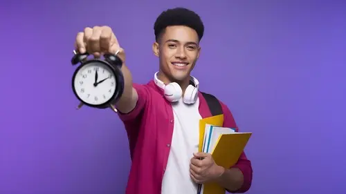 smiling-young-male-student-wearing-headphones-around-neck-holding-note-book-note-pad-folder.jpg