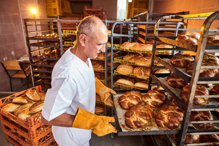 experienced-baker-handling-freshly-baked-bread.jpg