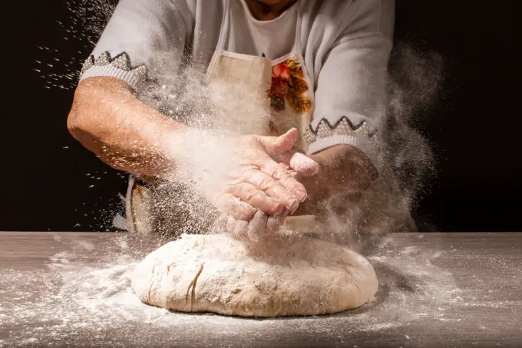 senior-baker-kneading-dough-with-flour.jpg