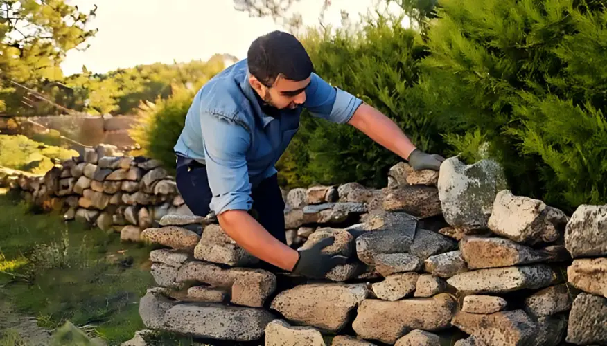 man-building-stone-garden-wall.jpg