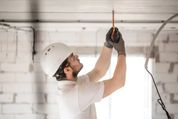 electrician-installer-with-tool-his-hands-working-with-cable-construction-site_169016-5885.jpg