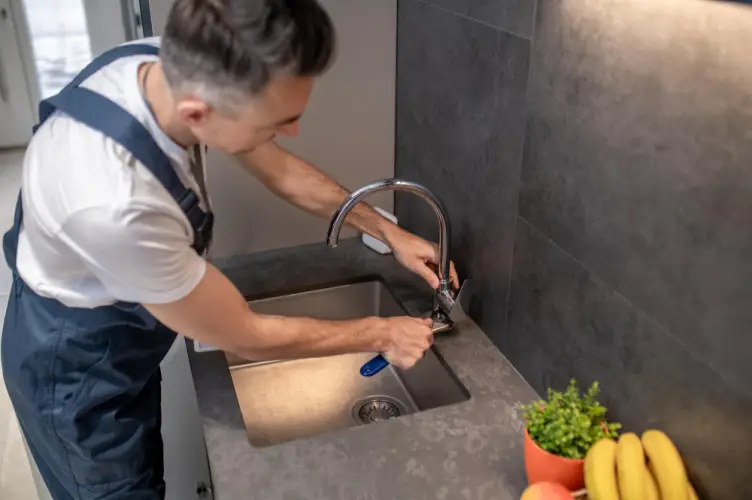 plumber-tightening-faucet-kitchen-sink.jpg