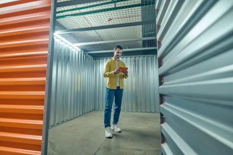 young-man-using-digital-tablet-in-storage-unit.jpg