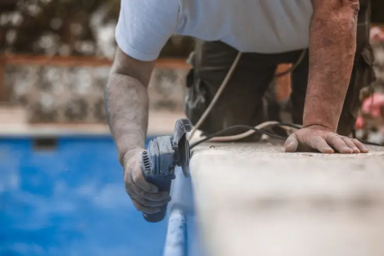 pool-maintenance-worker-grinding-edge-of-inground-pool.jpg