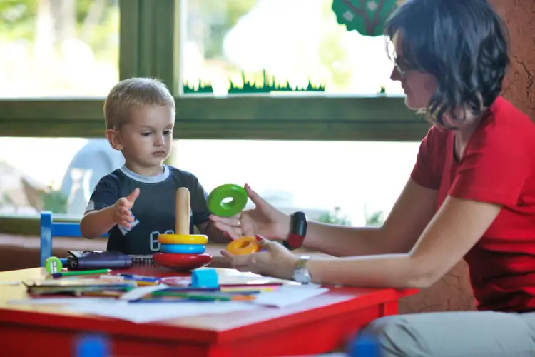 daycare-teacher-playing-with-toddler-in-learning-center.jpg