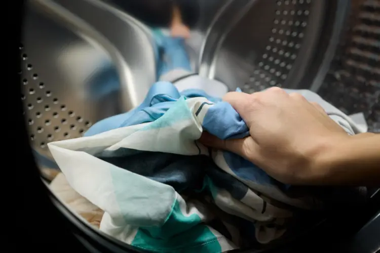 hand-putting-clothes-in-washing-machine.jpg