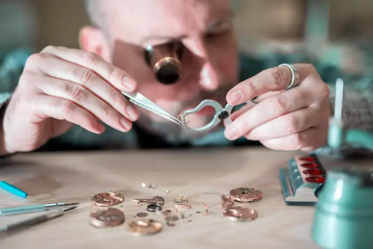 watchmaker-inspecting-tiny-gear-with-tweezers.jpg