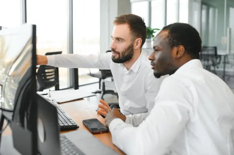 two-it-professionals-pointing-at-desktop-screen.jpg