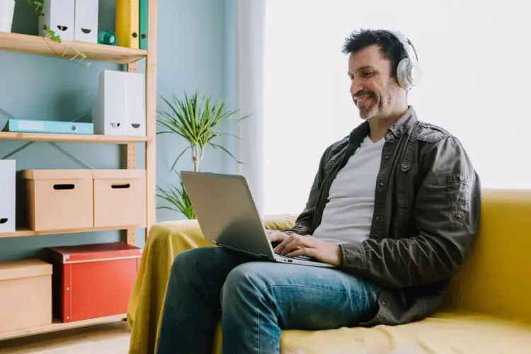 man-using-laptop-on-yellow-couch-at-home.jpg