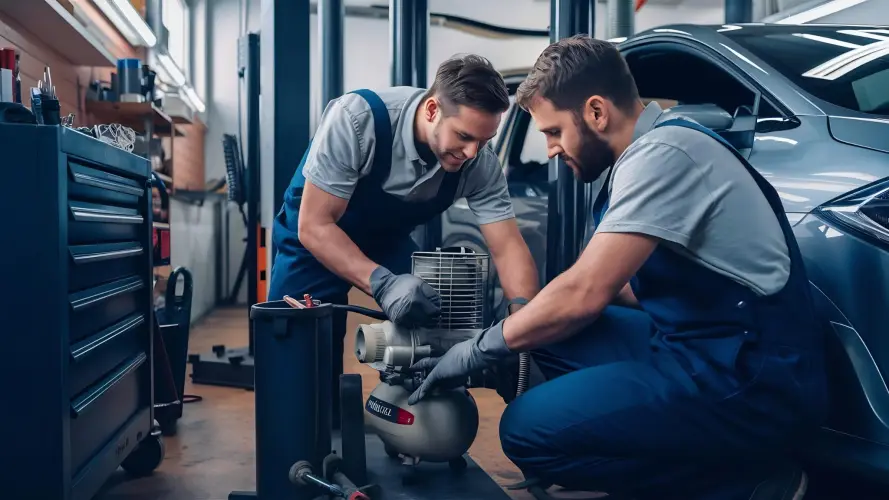 two-mechanics-using-air-compressor-auto-repair-shop.jpg
