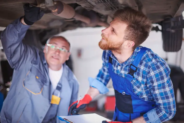 mechanics-inspecting-under-car-exhaust-with-clipboard.jpg