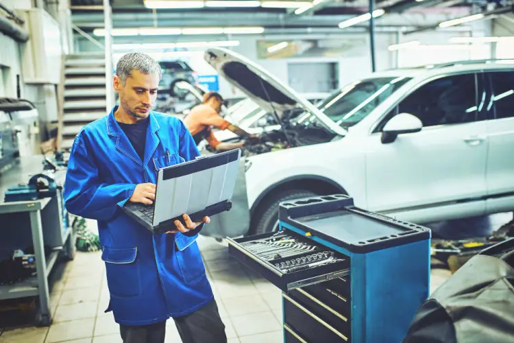auto-mechanic-diagnosing-car-with-laptop-workshop.jpg