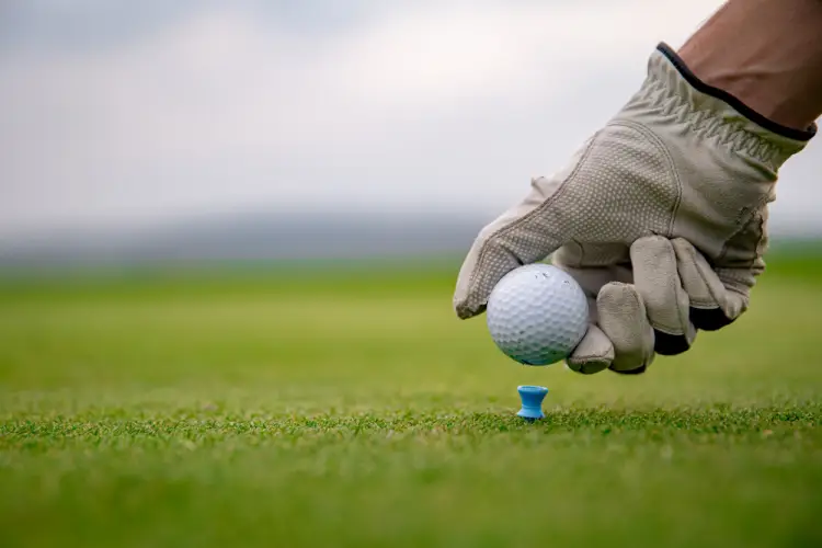 golf-ball-on-tee-gloved-hand.jpg
