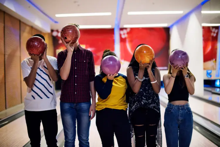 friends-holding-bowling-balls-fun-night.jpg