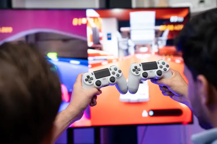 friends-holding-ps4-controllers-playing-racing-game.jpg