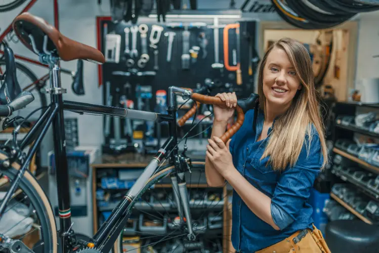 female-mechanic-holding-bike-in-workshop.jpg