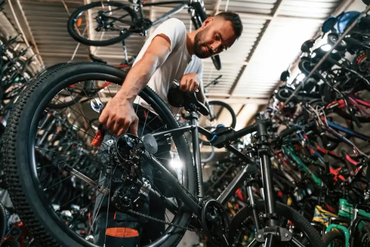 bike-repairman-fixing-gear-in-bike-shop.jpg