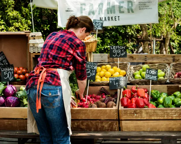 woman-arranging-organic-produce-at-farmers-market.jpg