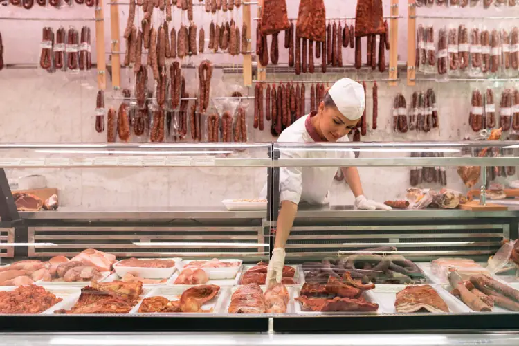 female-butcher-organizing-sausages-display.jpg