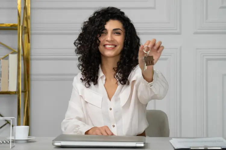 female-realtor-holding-house-keys-office.jpg