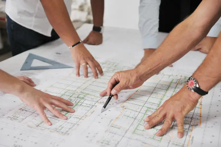 architects-hands-pointing-at-blueprints-on-table.jpg
