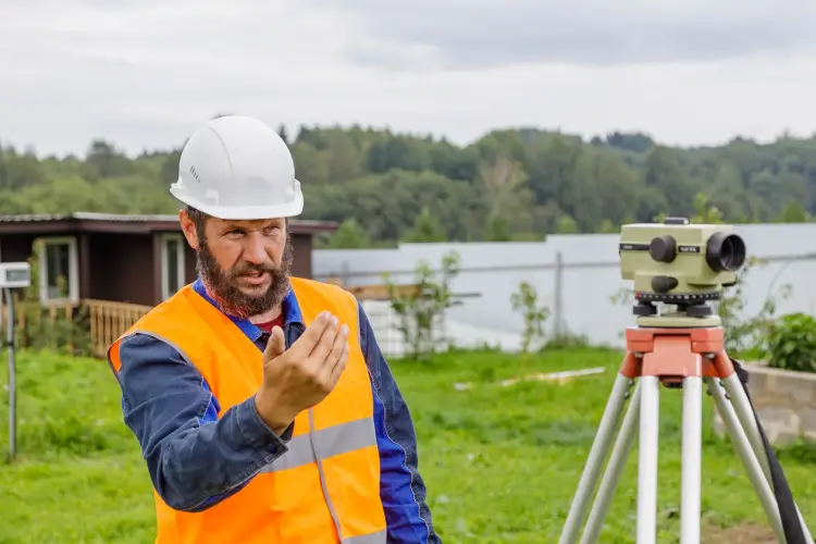 civil-engineer-with-optical-level-waves-his-hand-control-colleagues-from-distance.jpg