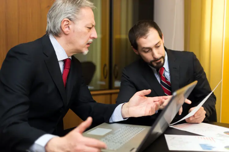 senior-and-young-businessmen-reviewing-documents.jpg
