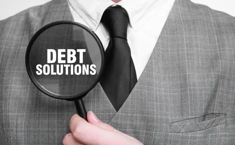 businessman-holding-magnifying-glass-debt-solutions.jpg