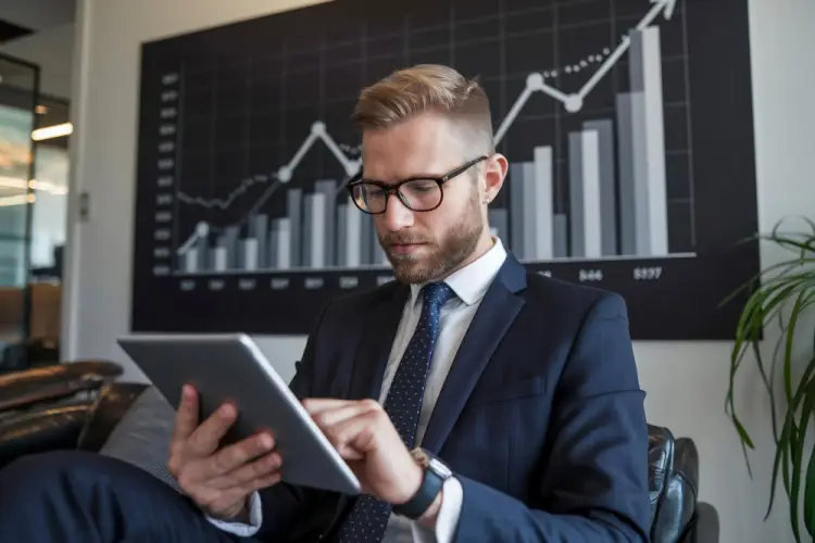 businessman-using-tablet-with-rising-stock-chart-background.jpg