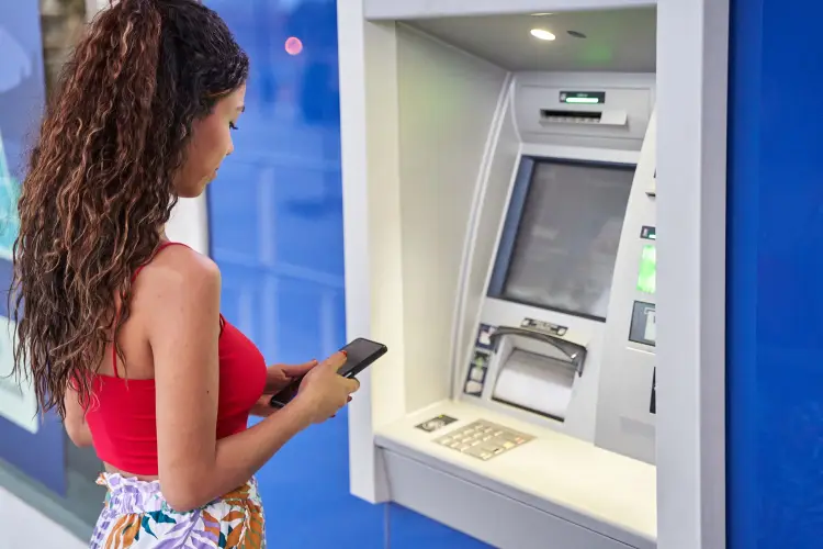 young-woman-withdrawing-cash-atm-using-her-smart-phone.jpg