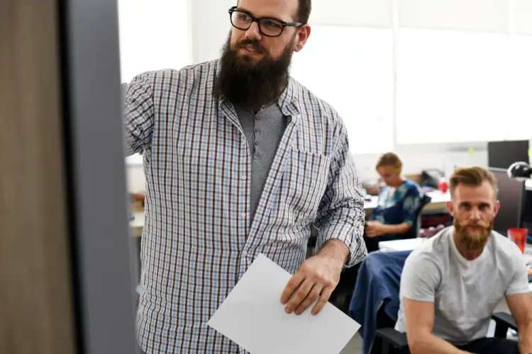 bearded-man-explaining-ideas-to-colleagues-on-whiteboard.jpg