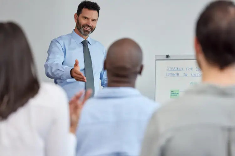 businessman-speaking-in-front-of-whiteboard-strategy-session.jpg
