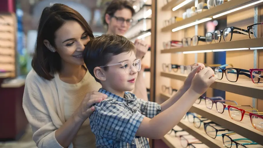 mother-helping-son-choose-glasses-in-store.jpg