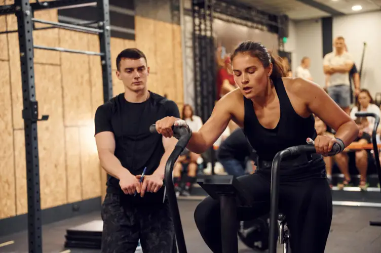 woman-doing-cardio-bike-workout-with-trainer.jpg