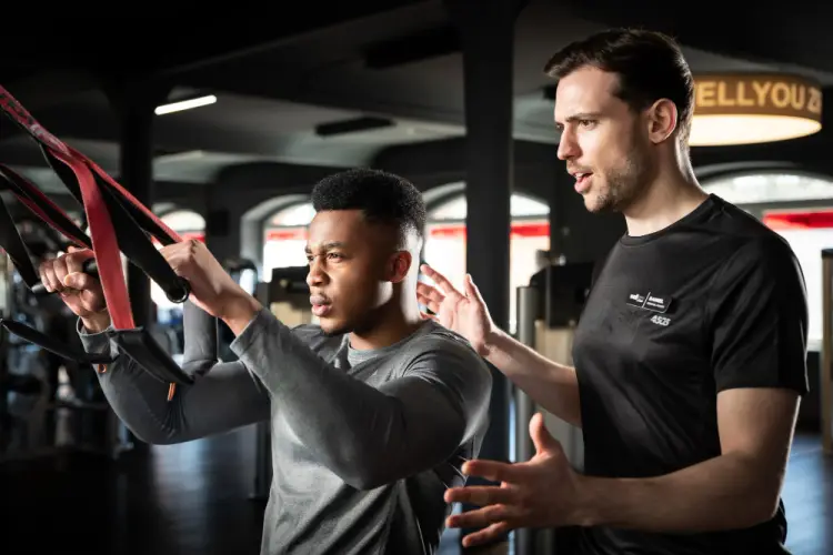 trainer-guiding-man-on-resistance-band-exercise.jpg