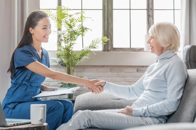 home-nurse-shaking-hands-with-elderly-woman-in-living-room.jpg
