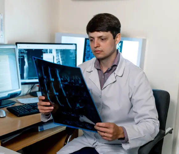 doctor-examining-spinal-xray-with-multiple-monitors.jpg