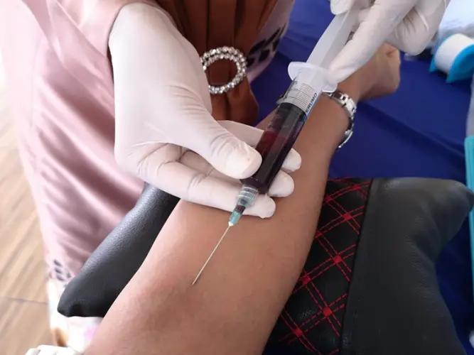 midsection-doctor-removing-blood-through-injection-clinic.jpg