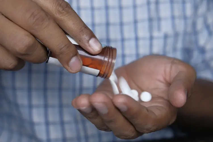 close-up-mans-hand-taking-pills-from-container.jpg