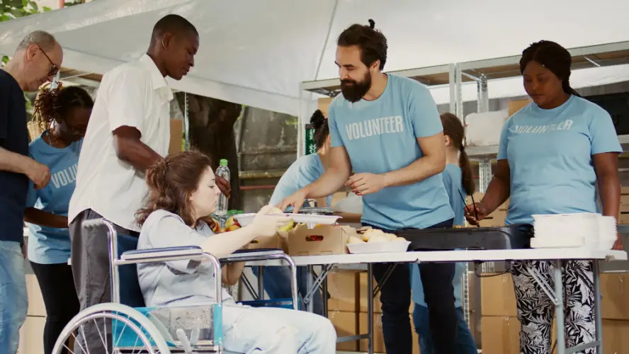 volunteers-serving-meal-to-woman-in-wheelchair.jpg
