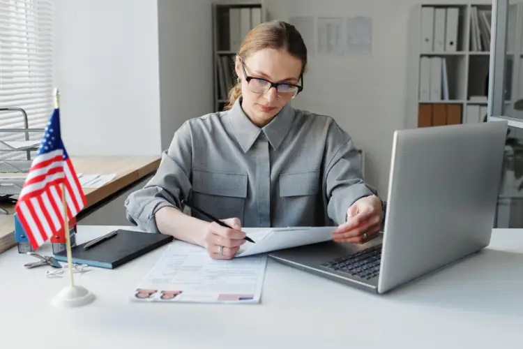 business-woman-sitting-at-desk-US-flag.jpg