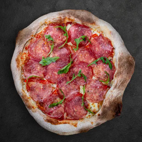 salami-pizza-with-arugula-on-dark-surface.jpg