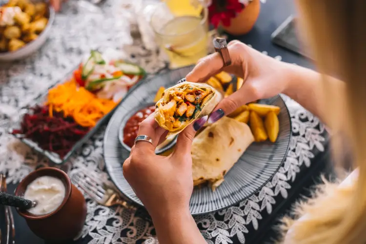 woman-holding-burrito-at-mexican-dining-table.jpg