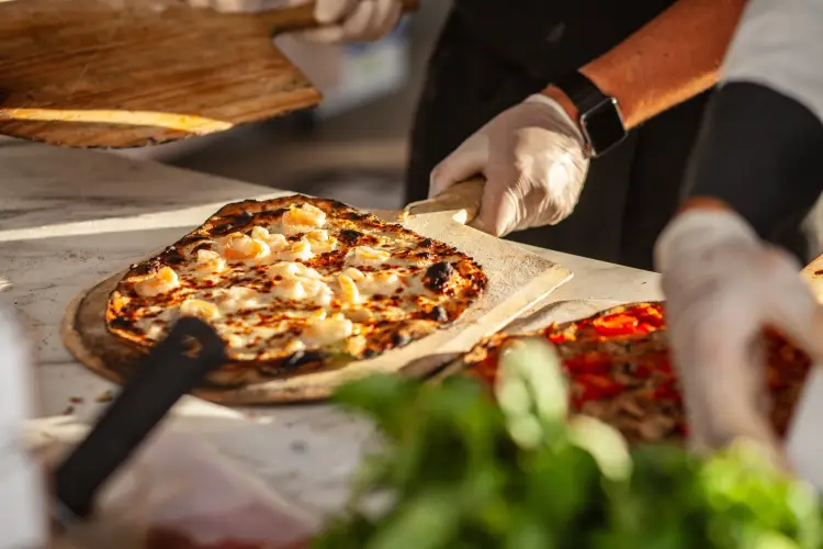 artisan-shrimp-pizza-being-served-on-wooden-paddle.jpg