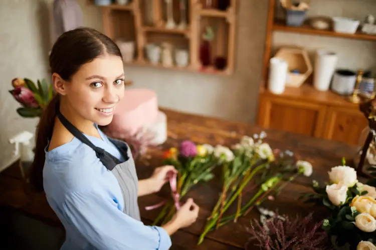 smiling-young-woman-organizing-flowers-on-table.jpg