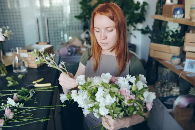 redhead-woman-creating-white-flower-arrangement.jpg