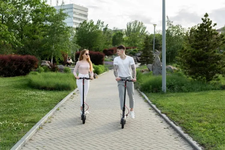 young-couple-riding-electric-scooters-in-park.jpg