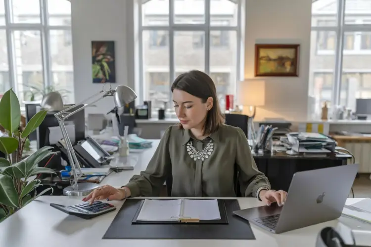 female-financial-analyst-with-calculator-and-laptop.jpg
